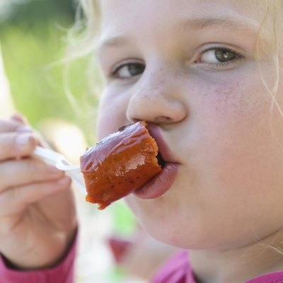 Young girl eating sausage