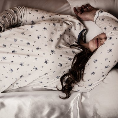 woman lying in bed with flu and fever feeling sick