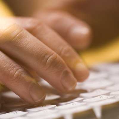 Close-up of person typing on a computer keyboard