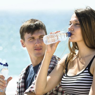 travelers drinking cold water on the beach