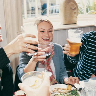 Friends Lifting their Glasses and Celebrating in a Restaurant