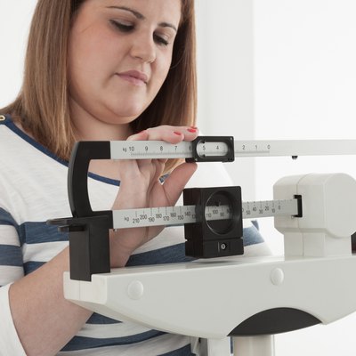 Woman adjusting a medical weight scale