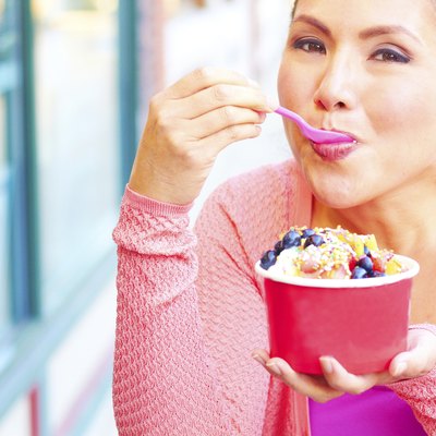 Happy Young Pretty Mixed Race Female Eating Frozen Yogurt