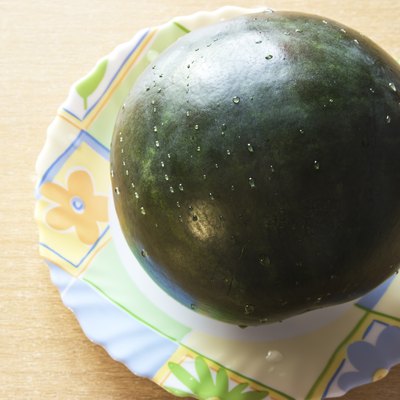 Fresh watermelon on the plate at wooden background
