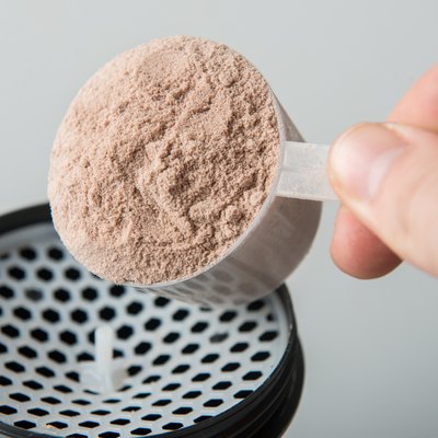 man hand with jar and bottle preparing protein shake