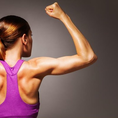 Strong hands back and shoulder of fit young woman who exercise, dramatic portrait