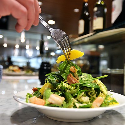 Man Enjoying Hand Tossed Salad with Oranges and Fresh Shrimp