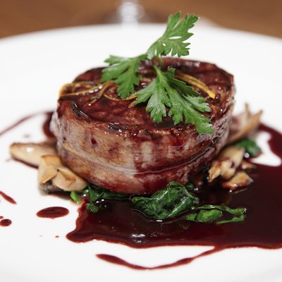 Tenderloin steak wrapped in bacon with red sauce
