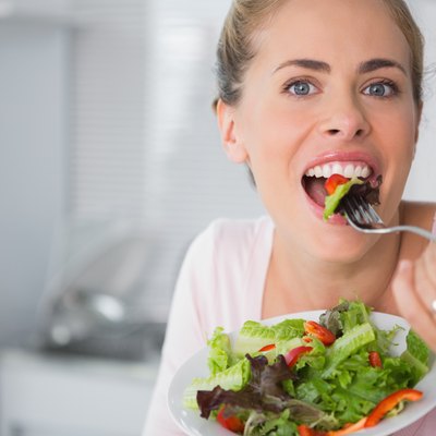 Casual blonde posing while eating salad