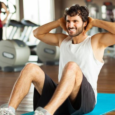 young man making abdominal exercises in gym