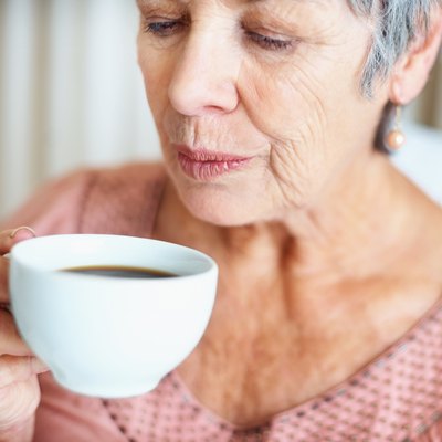 Senior lady blowing her hot coffee