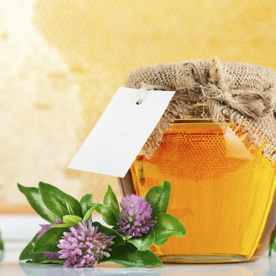 sweet honey in glass jars with flowers