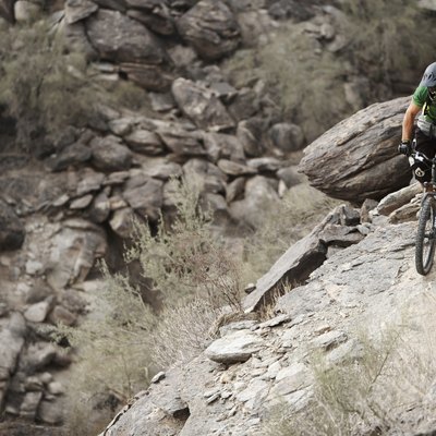 Rider mountain biking along cliff