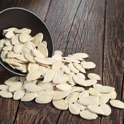 Pumpkin seeds in bowl and near