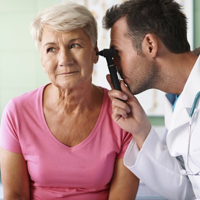 Doctor examining ear of senior woman