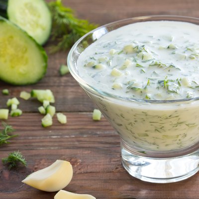 Traditional greek sauce Tzatziki and ingredients. Yogurt, herbs, garlic cucumber