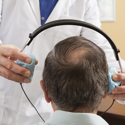 Audiologist placing a headset on a patient for audiometric evaluation