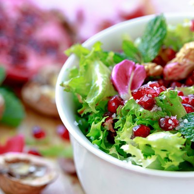Curly endive salad with pomegranate, nuts, rose petals...