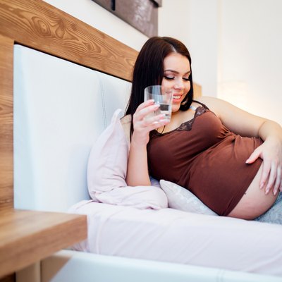 Beautiful pregnant woman drinking water