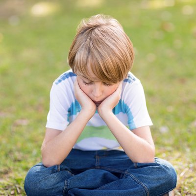 Little boy feeling sad in the park
