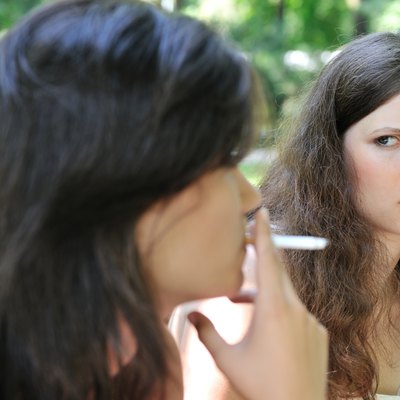 Young people outdoors - annoying by smoking cigarette