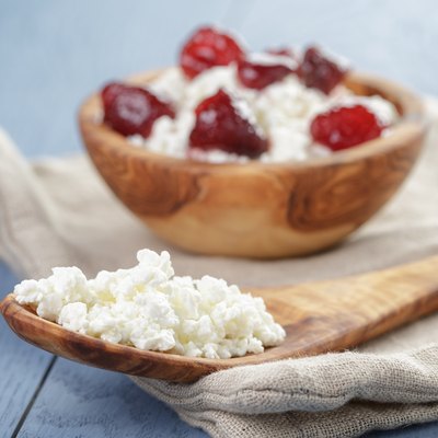 cottage cheese with preserved strawberry on blue table,