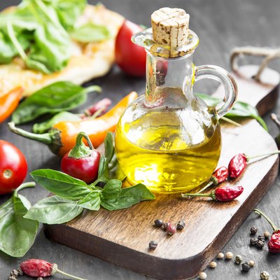 Olive Oil with Spices and Herbs on Wooden Board