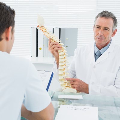 Doctor explaining spine to a patient in office