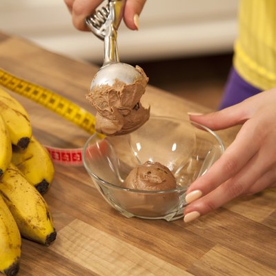 Serving chocolate ice cream into a bowl.
