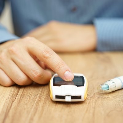 man testing glucose level with a digital glucometer, diabetes treatment
