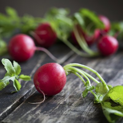 Fresh radishes on old wooden table