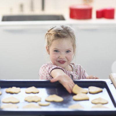 Girl with cookie dough on baking tray