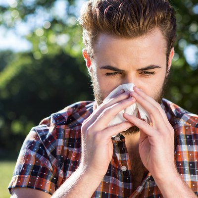 Handsome hipster blowing his nose