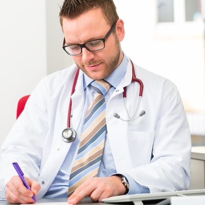 Young doctor writing medical prescription