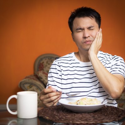 Asian man has a hypersensitive teeth and toothache while eating