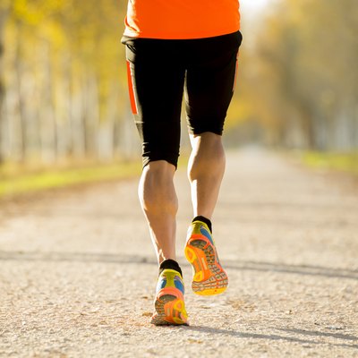 sport man legs with strong calves muscle running off road