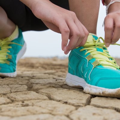 Runner feet running on road closeup on shoe