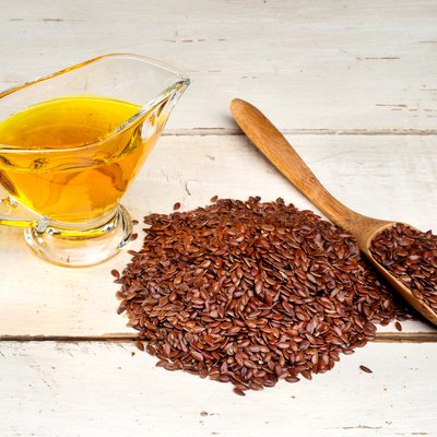 brown flax seed and linseed oil, on wooden table