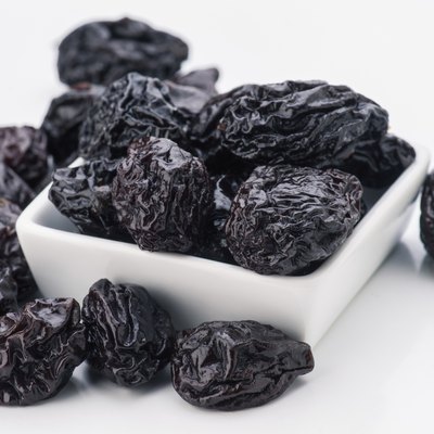 lot of prunes in transparent glass bowl