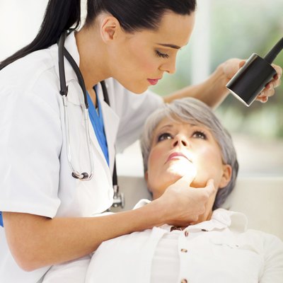 dermatologist inspecting middle aged patient's skin