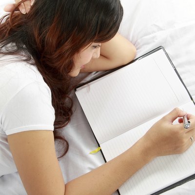 girl writing book on the bed