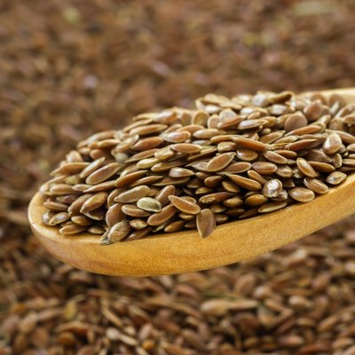 Flax seeds close up on a wooden spoon.