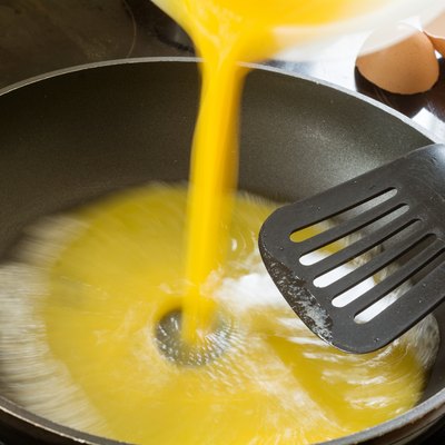 beaten egg flowing into the pan for scrambled eggs
