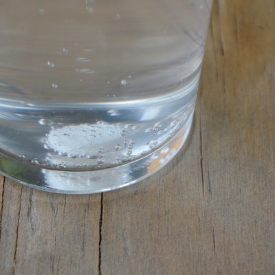 antacids in water glass on wooden table