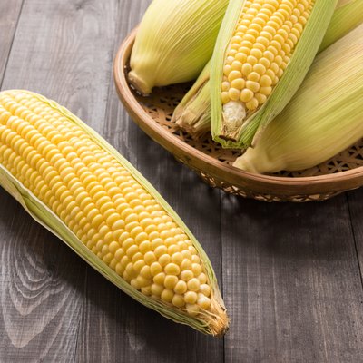 Fresh organic yellow sweet corn on wooden table