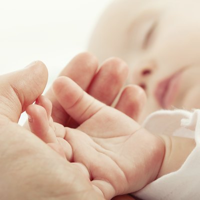 sleeping baby in hand of mother