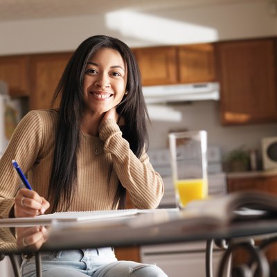 happy teen girl doing home work