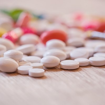 Pills and capsules on the wooden background