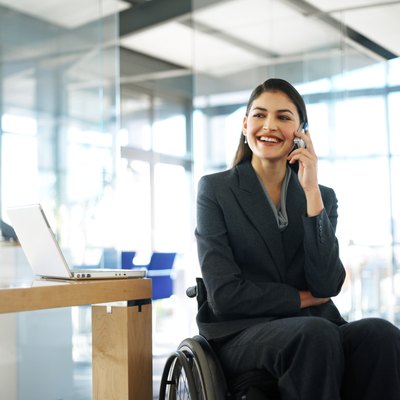 businesswoman sitting in a wheelchair talking on her mobile phone