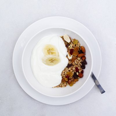elevated view of a bowl muesli with banana and cream